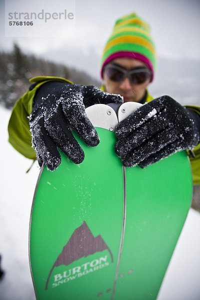 Ein Hinterland Snowboarder zusammenstellt seine Splitboard für die Fahrt nach unten  Tryst See  Kananaskis  Alberta  Kanada