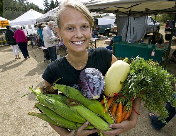 Ein junger Verkäufer zeigt stolz ihre frisch angebaute Produkte an der Cedar-Bauernmarkt. Zeder  zentrale Vancouver Island  British Columbia  Kanada.