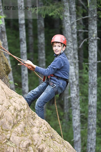 Ein kleiner Junge Rappells unten ein Kliff bei Horne See Klettern Freigelände  nahe Qualicum Beach  zentrale Vancouver Island  British Columbia  Kanada.