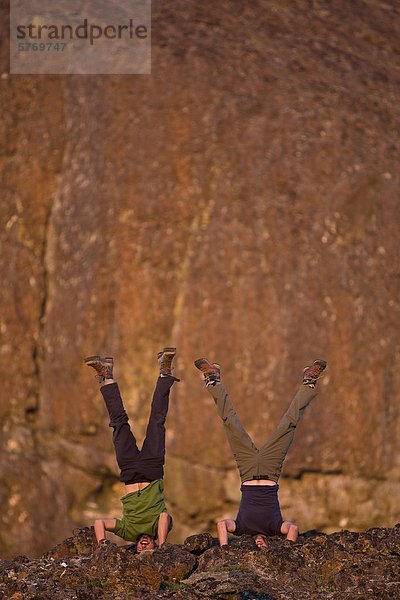 Zwei Freunde Streik Yoga-Posen im Camp  während der Nordwest-Grat der Elkhorn Kletterberg. Strathcona Park  zentrale Vancouver Island  British Columbia  Kanada