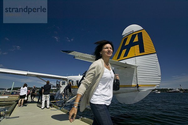 Eine junge Frau kommt in Nanaimo über Harbour Air Linienflug Betrieb an Nanaimo der Waterfront. Nanaimo  zentrale Vancouver Island  British Columbia  Kanada.