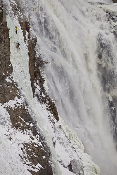 Zwei Eiskletterer steigen die berühmten Montmorency Falls  Kanada