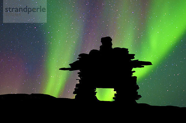 Inukshuk silhouetted gegen die Nordlichter  Barrenlands  zentrale Nordwest-Territorien Kanadas Arktis