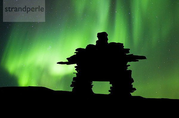 Inukshuk silhouetted gegen die Nordlichter  Barrenlands  zentrale Nordwest-Territorien Kanadas Arktis