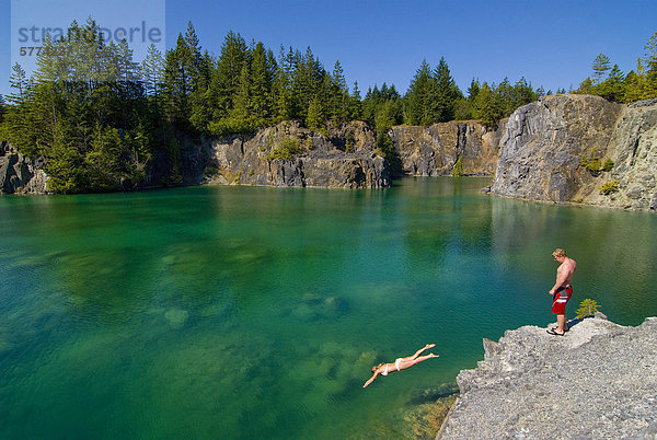Junges Paar genießen Sie eintauchen in die spektakuläre Smaragdwasser der Heisholt See auf Texada Island  an der Sunshine Coast in der Region Vancouver  Küste und Berge von British Columbia  Kanada