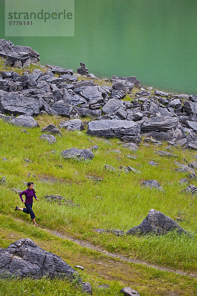 Eine junge asiatische Frau Trail-Läufer entlang des Ufers des Medicine Lake  Jasper Nationalpark  Alberta  Kanada