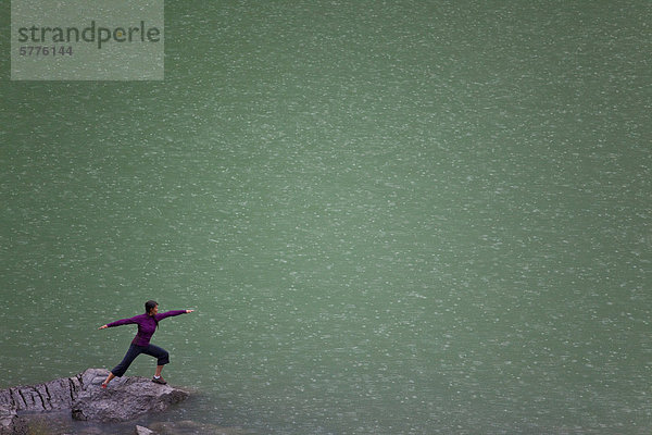 Eine Frau tut Yoga im Regen am Medicine Lake Jasper Nationalpark  Alberta  Kanada