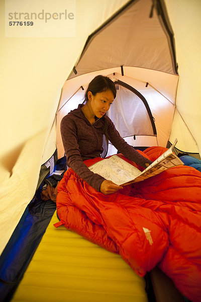Eine junge Frau wacht auf und plant den Tag beim camping in Jasper Provincial Park  Alberta  Kanada