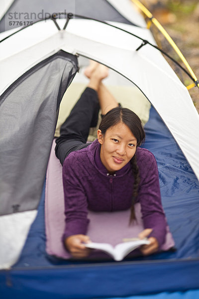 Eine glückliche  gesunde Frau tut etwas zu lesen beim camping in Jasper Nationalpark  Alberta  Kanada