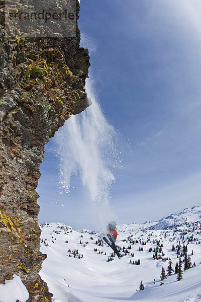 Ein männlicher Freeskier Allüren einer großen Felsen während Skitouren in den Monashee Berge  Britisch-Kolumbien  Kanada