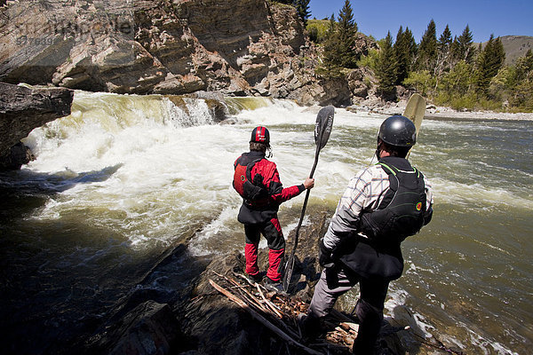 Zwei männliche Wildwasser-Kajaker scout die Wasserfälle auf der Oldman River  Alberta  Kanada