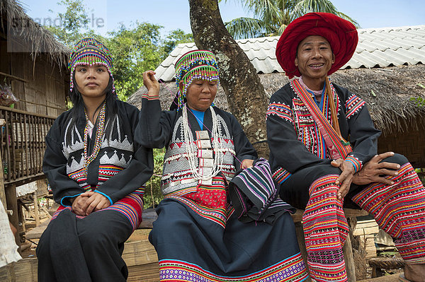 Traditionell gekleideter Mann und zwei Frauen aus dem Bergstamm oder Bergvolk Schwarze Hmong  ethnische Minderheit aus Ostasien  bei der Handarbeit  Stickerei  Nordthailand  Thailand  Asien