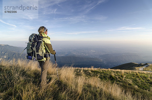 Wanderin mit Rucksack blickt vom Col Visentin in die Weite der Piave-Ebene  Italien  Europa