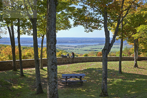 Paar sitzt auf Stein gemauerte Geländer mit Blick auf den Ottawa River  Gatineau Park  Gatineau  Québec  Kanada.