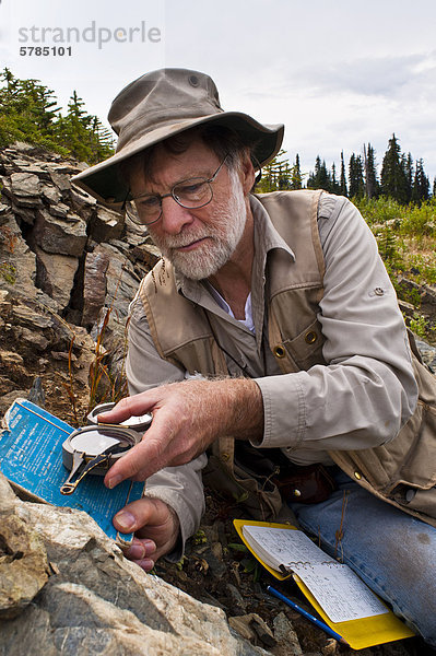 Ein Geologe Maßnahmen  Streik und Sprung von einem Felsen Aufschluss Durring ein Mineral Exploration Program  British Columbia  Kanada