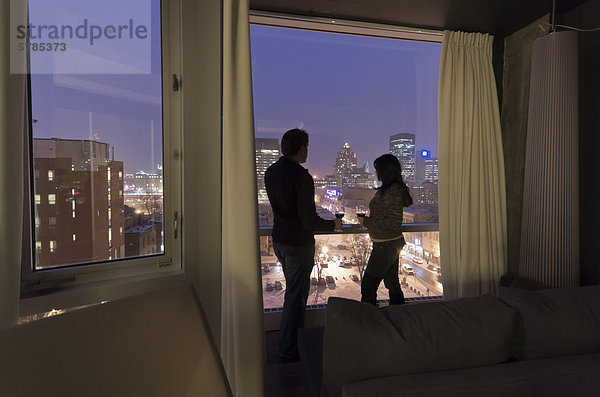 Paar mit einem Glas Wein in einem Montreal Hotel mit Blick auf auf den alten Montreal-Seite der Stadt bei Nacht  Kanada