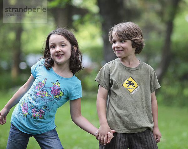 Junge und Mädchen Hand in Hand  im Freien  Gimli  Manitoba  Kanada