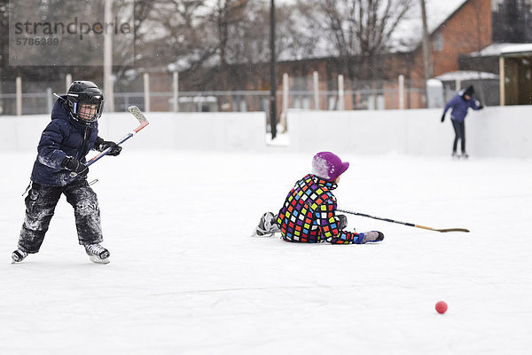 Boys playing ice hockey  on an outdoor rink  Winnipeg  Manitoba  Canada