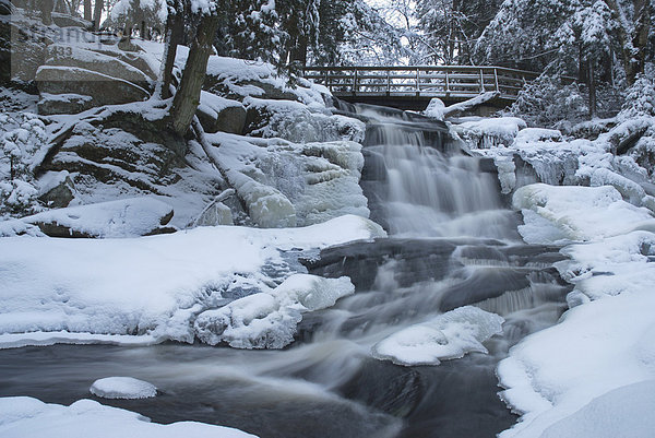 Wenig hohe Wasserfälle und Fußgängerbrücke im Winter in der Nähe von Bracebridge  Ontario