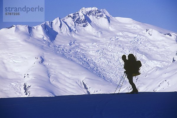 Mann hält zum Anzeigen von Mount Tisiphone  Küste-Strecke  auf der Lillooet Icefield Traverse  British Columbia  Kanada.