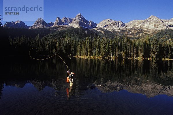 Junger Mann Fliegenfischen auf Island Lake im Bereich Eidechse nahe Fernie  Britisch-Kolumbien  Kanada.
