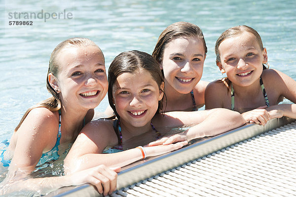 Vier lächelnde Mädchen im Freibad