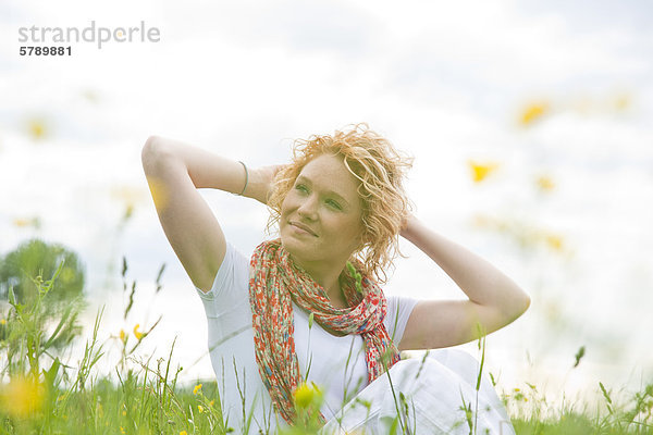 Lächelnde junge Frau auf einer Blumenwiese
