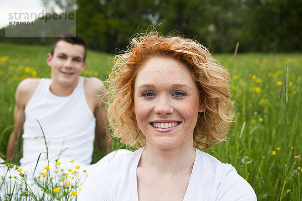 Lächelndes junges Paar auf einer Wiese
