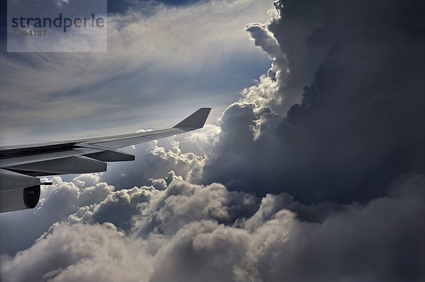 Tragfläche von einem Flugzeug mit dramatischer Wolkenformation