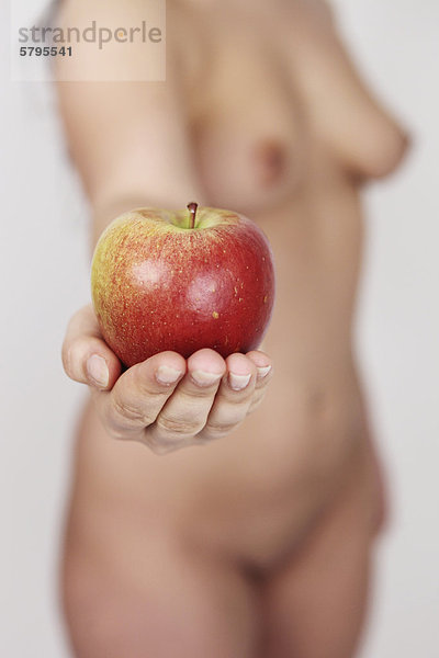 Frau  nackter Oberkörper  hält Apfel in der Hand