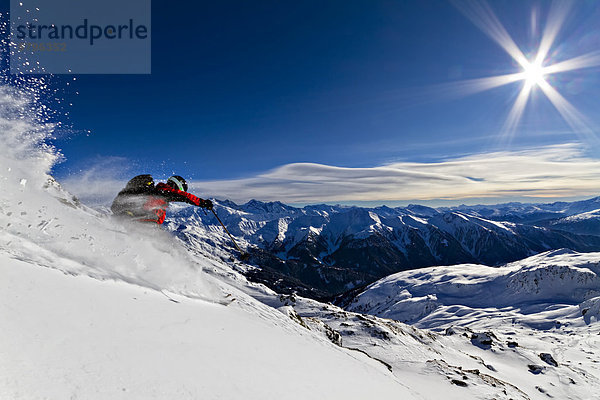 Skifahrer im Pulverschnee mit Sonnenschein  Tuxer Alpen  Tirol  Österreich  Europa