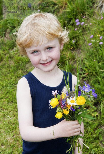 Kleiner Junge mit Blumenstraußaus Wiesenblumen