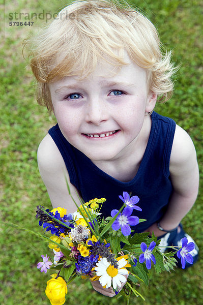 Kleiner Junge mit Blumenstraußaus Wiesenblumen