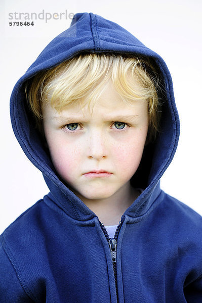 5-jähriger Junge mit Kapuzenjacke schaut grimmig  Portrait