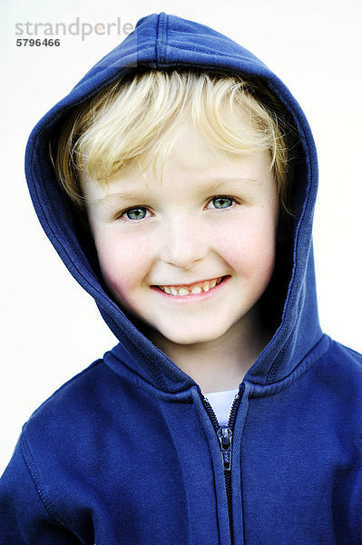 5-jähriger Junge mit Kapuzenjacke lächelt  Portrait