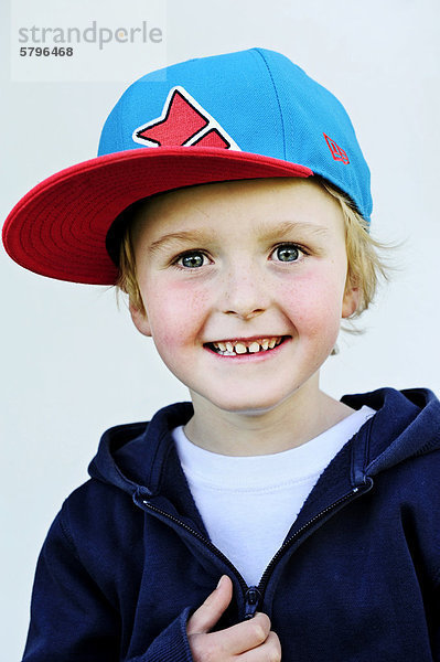 5-jähriger Junge mit Schildmütze lächelt  Portrait