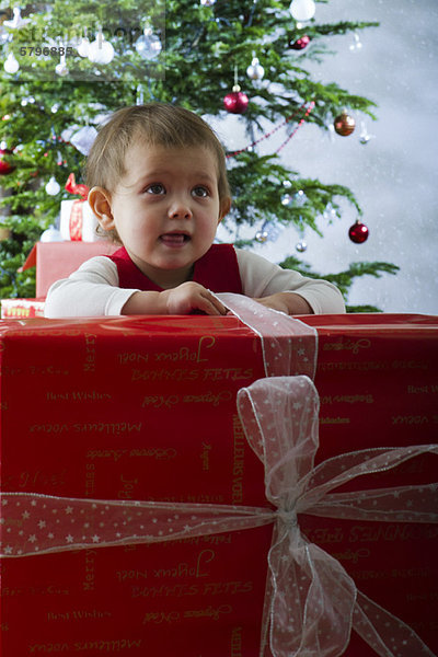 Baby Mädchen eröffnet großes Weihnachtsgeschenk