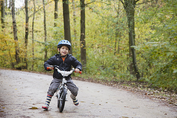 Junge auf dem Fahrrad  lächelnd vor der Kamera