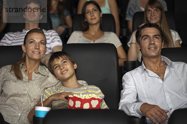 Familie genießt Film im Theater  Junge ruht Kopf auf der Schulter seiner Mutter