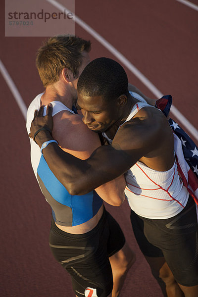Amerikanische Mannschaftskameraden umarmen sich nach dem Rennen