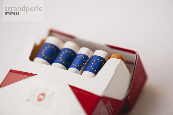 Zigarettenpackung mit gerollten Euros