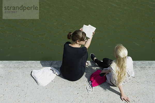 Junge Frauen entspannen sich gemeinsam am Kanal