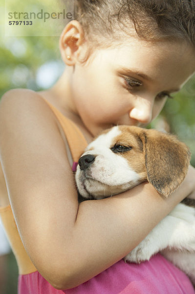 Mädchen küssender Beagle-Welpe