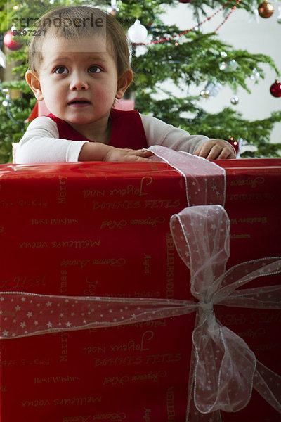 Baby Mädchen eröffnet großes Weihnachtsgeschenk