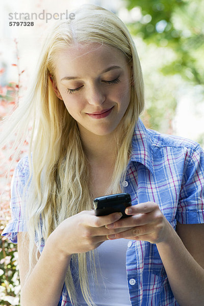 Junge Frau SMS mit Handy