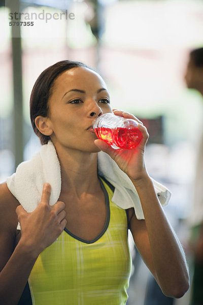 Junge Frau trinkt Sportgetränk nach dem Training