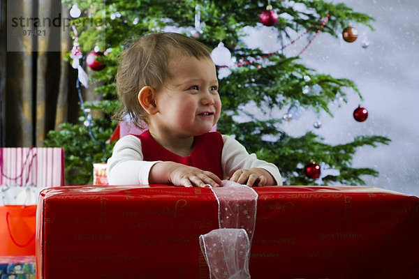 Baby Mädchen eröffnet großes Weihnachtsgeschenk