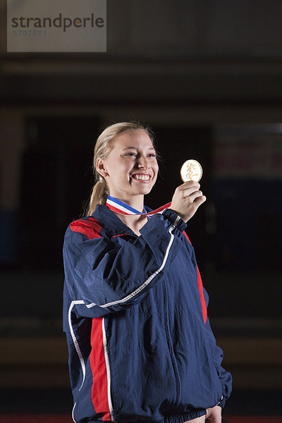 Lächelnde Sportlerin mit Goldmedaille