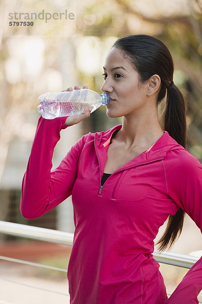 Junge Frau trinkt Wasserflasche