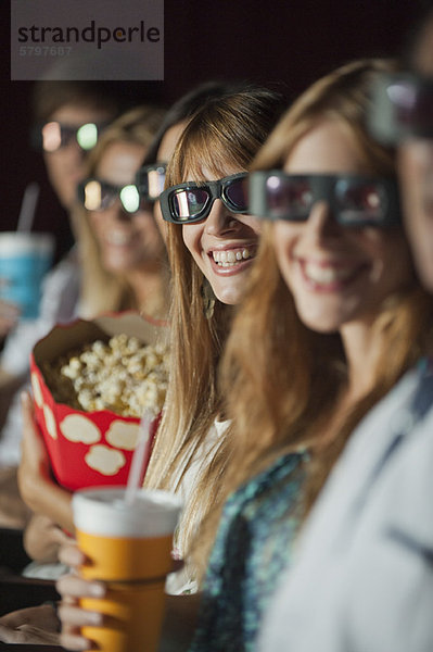 Publikum mit 3-D-Brille im Kino  lächelnd vor der Kamera